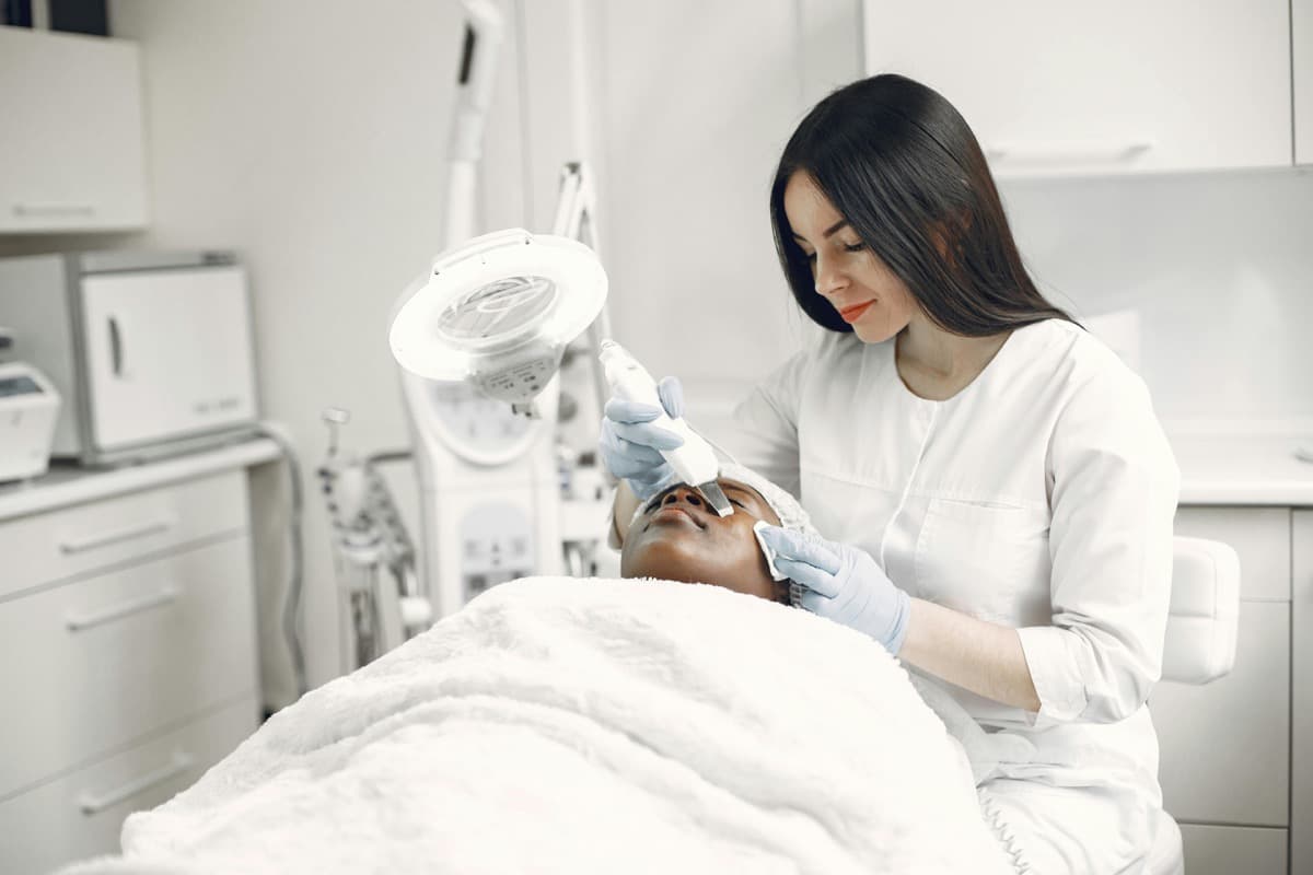 Cosmetic treatment performed beside a treatment chair in an aesthetic clinic as an editorial image for a skin treatment comparison