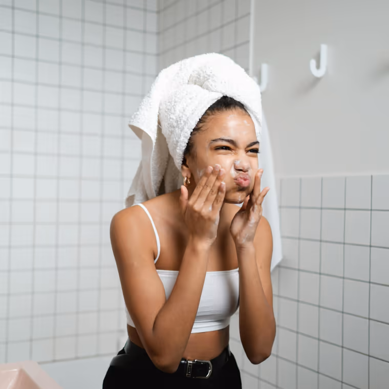 Woman looking in mirror, concerned about skin appearance